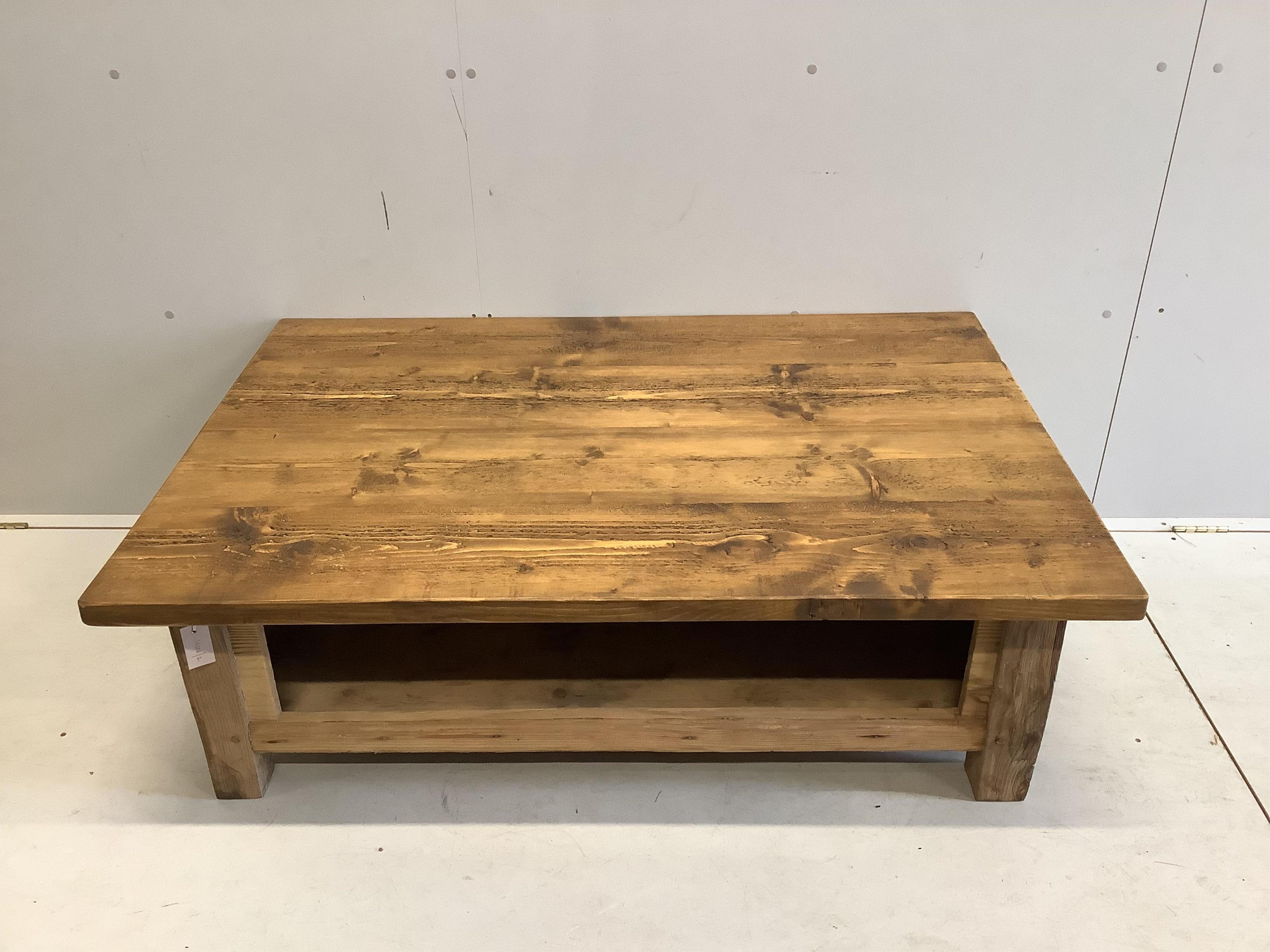 A rectangular pine two tier coffee table, width 129cm, depth 88cm, height 46cm. Condition - good